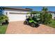 Well-maintained property showing a green golf cart parked in front of the garage on brick pavers at 19442 Sea Glass Cir, Land O Lakes, FL 34638