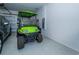 Clean, well-lit garage with epoxy flooring and a green golf cart parked inside at 19442 Sea Glass Cir, Land O Lakes, FL 34638