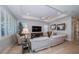 Cozy living room featuring a white leather sectional, wood flooring, and bright natural light at 19442 Sea Glass Cir, Land O Lakes, FL 34638
