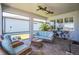Relaxing screened-in patio with comfortable wicker furniture, ceiling fan, and brick flooring at 19442 Sea Glass Cir, Land O Lakes, FL 34638