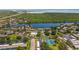 An aerial view of the residential area featuring a lake and various amenities like a swimming pool and tennis court at 195 114Th Ne Ave # 195, St Petersburg, FL 33716