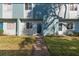 Townhome with a grassy front yard and concrete walkway leading up to the front door at 195 114Th Ne Ave # 195, St Petersburg, FL 33716