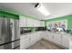 Well-equipped kitchen with stainless steel refrigerator and white cabinets, complemented by a window view at 195 114Th Ne Ave # 195, St Petersburg, FL 33716