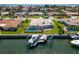 Stunning aerial view of a waterfront property featuring a screened pool, lush green lawn, private boat dock, and canal access at 2015 Hawaii Ne Ave, St Petersburg, FL 33703