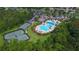 Overhead view of swimming pool and tennis courts within a vibrant community, surrounded by trees at 20606 Whitewood Way, Tampa, FL 33647
