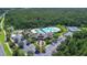 Panoramic view showcasing a community pool, playground, tennis courts, and clubhouse nestled in greenery at 20606 Whitewood Way, Tampa, FL 33647