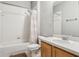Bathroom with a shower and bath combination, neutral tile, and a wooden vanity at 20606 Whitewood Way, Tampa, FL 33647