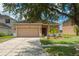 Charming single-story home featuring a well-manicured lawn, a two-car garage, and decorative landscaping at 20606 Whitewood Way, Tampa, FL 33647
