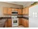 Kitchen with wood cabinets, black countertops, and white appliances at 20606 Whitewood Way, Tampa, FL 33647