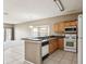 Bright kitchen with view to carpeted living room, light wood cabinets, and stainless steel appliances at 20606 Whitewood Way, Tampa, FL 33647