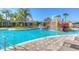 Splash into summer fun at this community pool featuring a splash pad and water slide under a bright blue sky at 20606 Whitewood Way, Tampa, FL 33647
