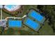 Aerial view of well-maintained tennis courts; perfect for active recreation in a serene, wooded setting at 20606 Whitewood Way, Tampa, FL 33647