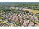 An aerial view highlighting neighborhood homes with backyard pools, mature trees, and a sports field in the distance at 2127 Landside Dr, Valrico, FL 33594