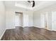 Bright bedroom offering hardwood floors, tray ceiling, multiple doors, and neutral paint at 2127 Landside Dr, Valrico, FL 33594