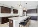 Modern kitchen featuring a large island, dark cabinets, quartz countertops, and stainless steel appliances at 2127 Landside Dr, Valrico, FL 33594