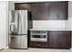 Kitchen with stainless steel refrigerator, built-in microwave, and dark wood cabinetry at 2127 Landside Dr, Valrico, FL 33594