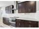 Modern kitchen features dark wood cabinets, stainless steel appliances, and white subway tile backsplash at 2127 Landside Dr, Valrico, FL 33594