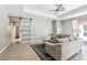 Comfortable living room with tile flooring, tray ceiling and sliding barn door to entryway at 2127 Landside Dr, Valrico, FL 33594