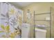 Small bathroom with modern sink, toilet, shelving unit, and decorative shower curtain at 225 Cevera Dr, Dunedin, FL 34698