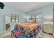 Bright bedroom with stylish bed, colorful bedding, two large windows, and light wood floors at 225 Cevera Dr, Dunedin, FL 34698