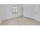 Bright, empty bedroom with light wood floors, a large window, and a spacious closet at 225 Cevera Dr, Dunedin, FL 34698