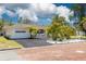 Charming single-story home with lush tropical landscaping, a brick-paved street, and an attached one-car garage at 225 Cevera Dr, Dunedin, FL 34698