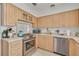 Well-lit kitchen featuring modern appliances and natural wood cabinets at 225 Cevera Dr, Dunedin, FL 34698