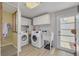 Bright laundry room featuring a washer, dryer, utility sink, cabinets, and a door to the outside at 225 Cevera Dr, Dunedin, FL 34698