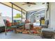 Relaxing screened porch with wicker furniture, a colorful area rug, and a view of the pool area at 225 Cevera Dr, Dunedin, FL 34698