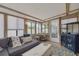 Bright sunroom with exposed beam ceiling, tile floors and comfortable seating at 225 Cevera Dr, Dunedin, FL 34698