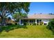 Lush backyard offers a well-manicured lawn, mature trees, and landscaping at 2333 Brookfield Greens Cir, Sun City Center, FL 33573
