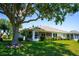Backyard features lush green lawn, mature trees and a screened-in patio at 2333 Brookfield Greens Cir, Sun City Center, FL 33573