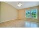 Bright, inviting bedroom with tile flooring, a ceiling fan, neutral paint, and a large window at 2333 Brookfield Greens Cir, Sun City Center, FL 33573