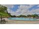 The community pool features lounge chairs, umbrellas and lush tropical landscaping at 2333 Brookfield Greens Cir, Sun City Center, FL 33573