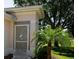 Elegant home entrance with a decorative screen door featuring a heron design, complemented by lush landscaping at 2333 Brookfield Greens Cir, Sun City Center, FL 33573