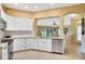Modern kitchen with white cabinets, stainless steel appliances, granite countertops, and tile flooring at 2333 Brookfield Greens Cir, Sun City Center, FL 33573