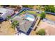 Aerial view featuring a screened-in pool, fenced yard, mature landscaping, and a storage shed at 2435 Comerwood Dr, Spring Hill, FL 34609