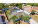 Aerial view of a home with a screened pool, fenced yard and mature trees at 2435 Comerwood Dr, Spring Hill, FL 34609