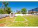 Spacious fenced backyard with a shed, artificial putting green and lush lawn at 2435 Comerwood Dr, Spring Hill, FL 34609