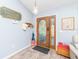 Charming foyer with wood-look flooring, decorative door with glass, and coat rack at 2435 Comerwood Dr, Spring Hill, FL 34609