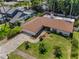 Aerial perspective of a home with a brown roof, paver driveway, and lush surroundings at 2486 Indian E Trl, Palm Harbor, FL 34683