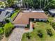Aerial shot of a well-maintained home with a brown roof, paver driveway, and landscaped yard at 2486 Indian E Trl, Palm Harbor, FL 34683