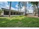 Spacious backyard showing the lanai, a green lawn, and a fence offering privacy and a defined property line at 2486 Indian E Trl, Palm Harbor, FL 34683