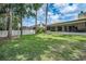 Large, grassy backyard with mature trees surrounding the property and a fence offering privacy and definition at 2486 Indian E Trl, Palm Harbor, FL 34683