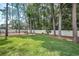 Expansive backyard featuring a manicured lawn, trees, and a crisp white fence that offers complete privacy at 2486 Indian E Trl, Palm Harbor, FL 34683