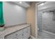 Bathroom vanity with marble countertops and a tiled shower in the background at 2486 Indian E Trl, Palm Harbor, FL 34683