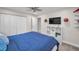 Bedroom with a blue bed, closet, and wall-mounted television for entertainment at 2486 Indian E Trl, Palm Harbor, FL 34683