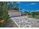 Paver driveway leading to the garage and front of the home, surrounded by landscaping at 2486 Indian E Trl, Palm Harbor, FL 34683