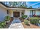 Inviting front entrance with a paver walkway and lush landscaping leading to double doors at 2486 Indian E Trl, Palm Harbor, FL 34683