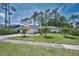 Well-maintained single-story home with a manicured lawn, mature trees, and a paved driveway at 2486 Indian E Trl, Palm Harbor, FL 34683